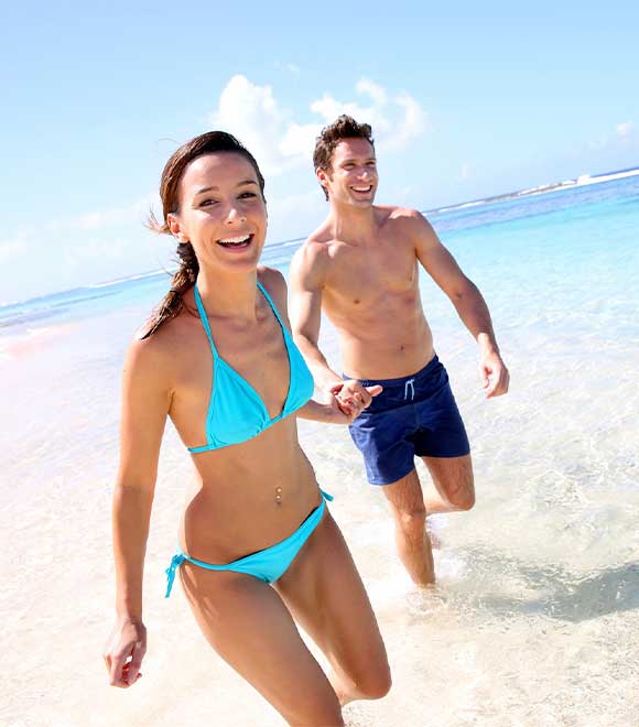 Healthy couple running on the beach